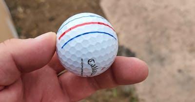 Someone holding a Callaway 2022 Chrome Soft Triple Track Golf Ball.