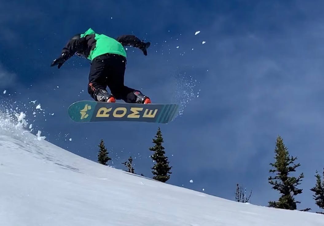 A snowboarder doing a jump trick.