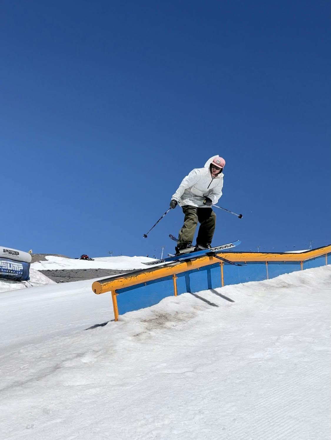 A skier hits a rail feature on skis. 