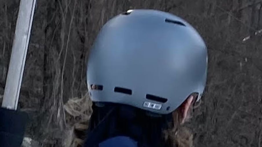 Back view of the Giro Ledge MIPS Helmet while someone wears it at a ski resort. 