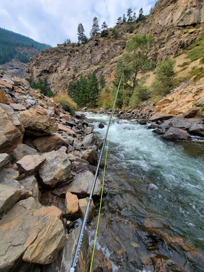 A fishing rod over some rapids.