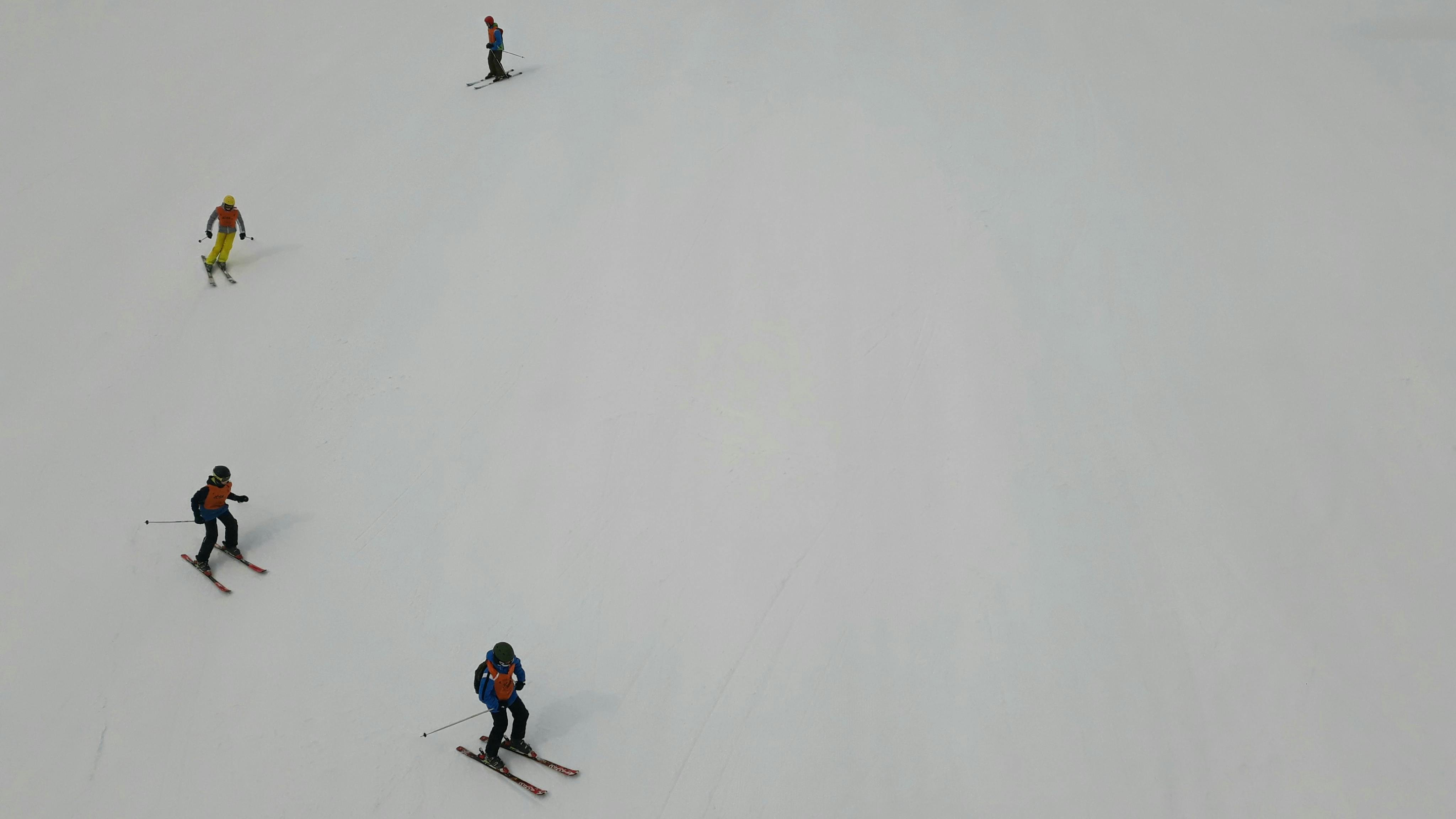 Four skiiers make a wide turn