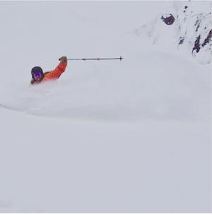 A skier turning down a very snowy ski run. 