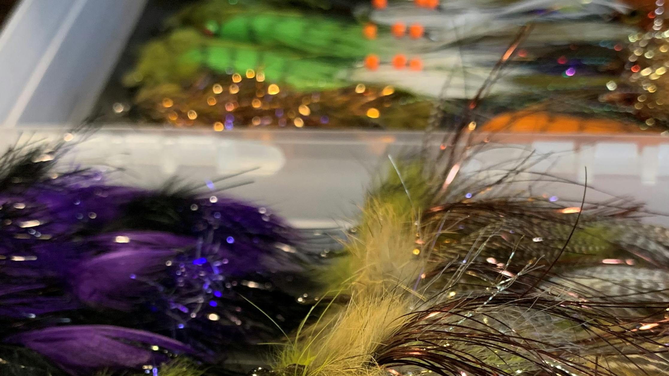 A shot of the open and completed fly box filled with colorful and sparkly streamers.  