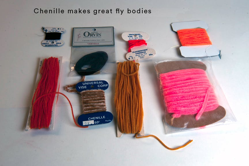 A collection of the author's yarn, in variations of pink, orange, red, rust, and black. The text reads, "Chenille makes great fly bodies."