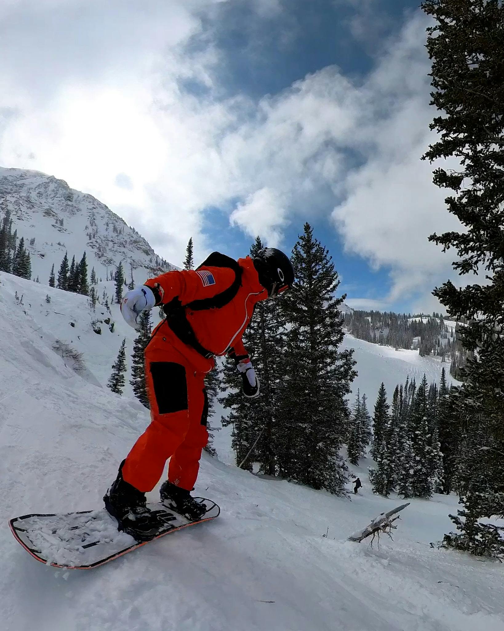 A snowboarder turning down a mountain. 