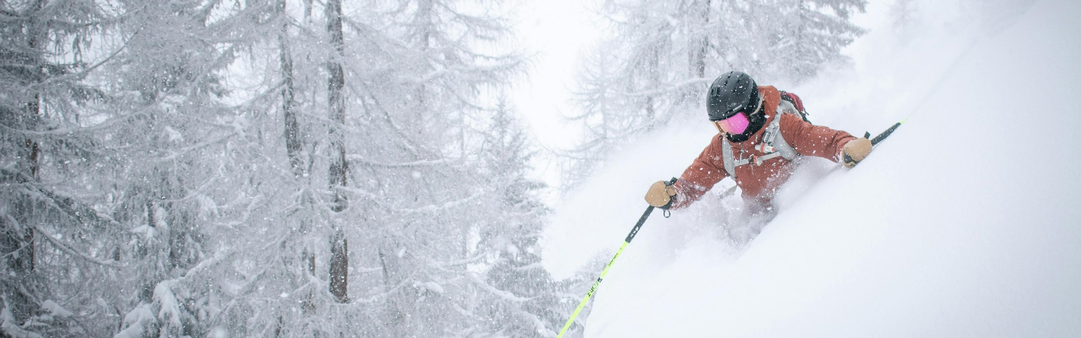A skier navigates through waist-deep powder