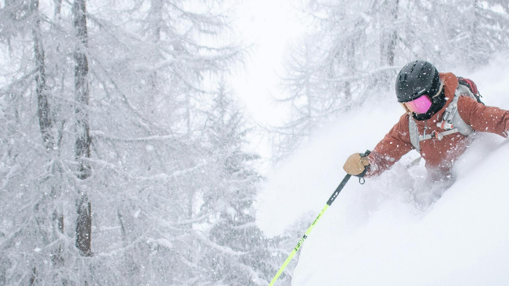 A skier navigates through waist-deep powder