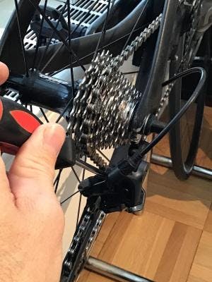 A hand adjusting Limit the Screws on a bike.