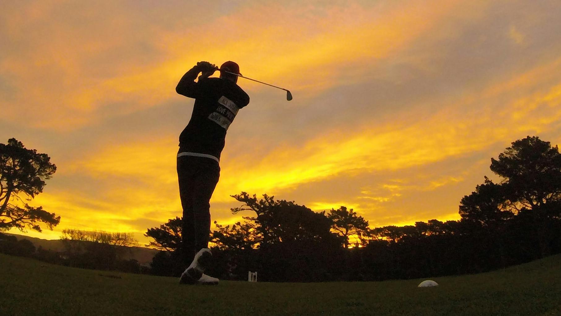 A golfer against the background of a sunset