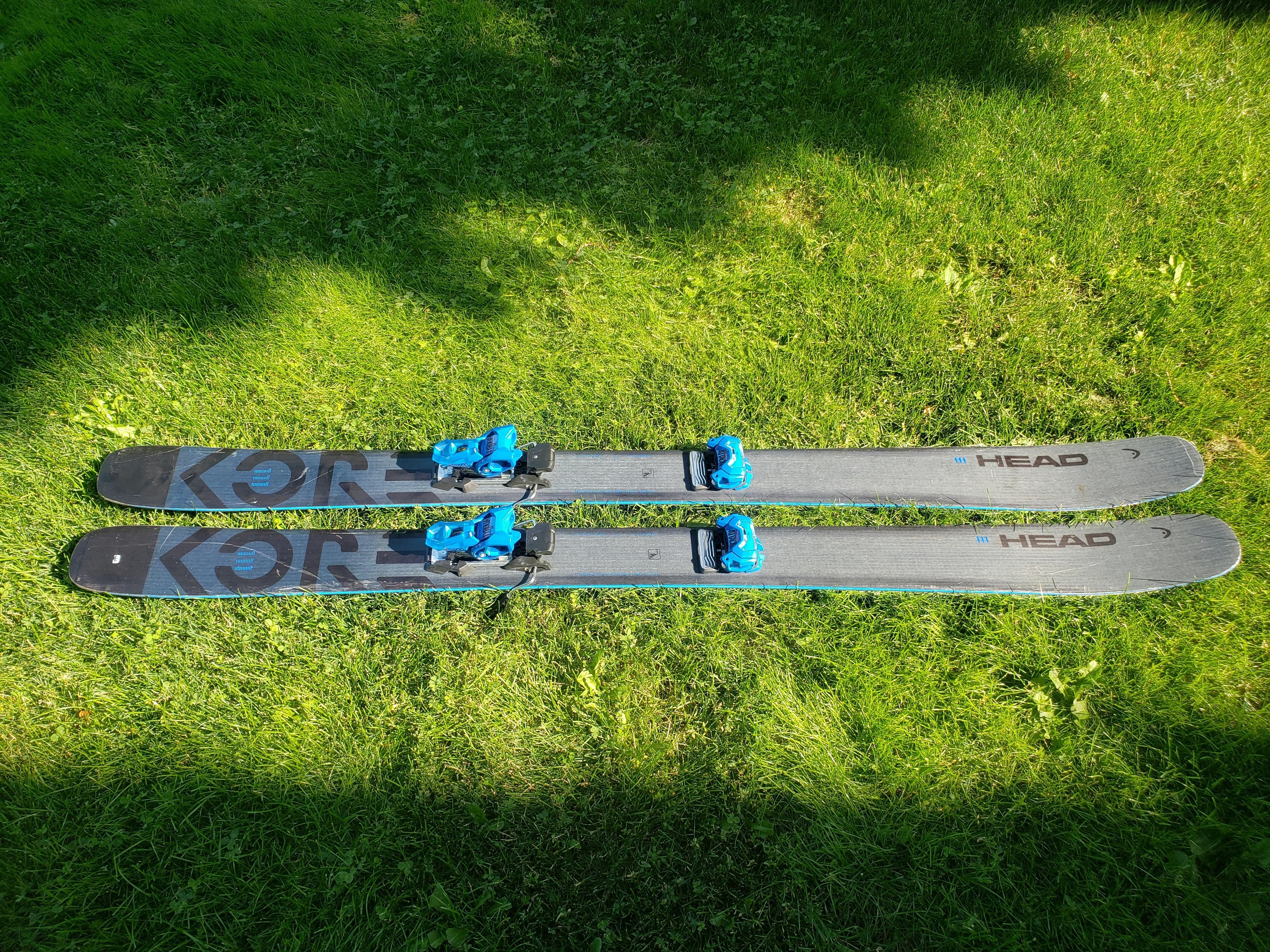 Skis laying in the grass with the Tyrolia Attack 14 Gw Ski Bindings mounted to them. 