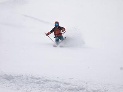 A man skiing down a snowy mountain. 