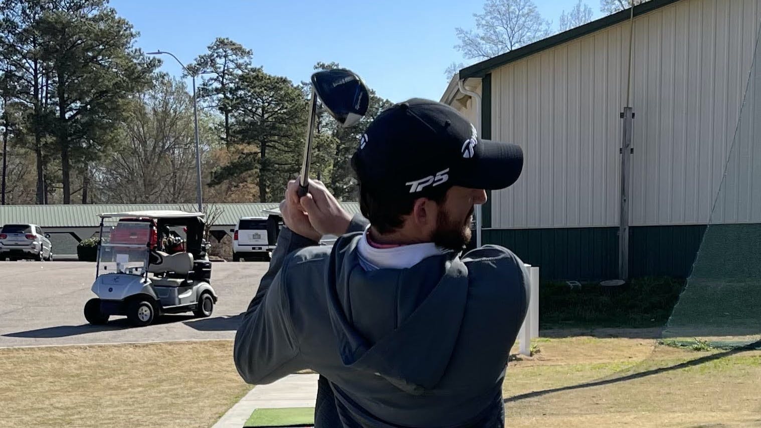 A golfer swinging the  TaylorMade SIM2 Max Rescue. 