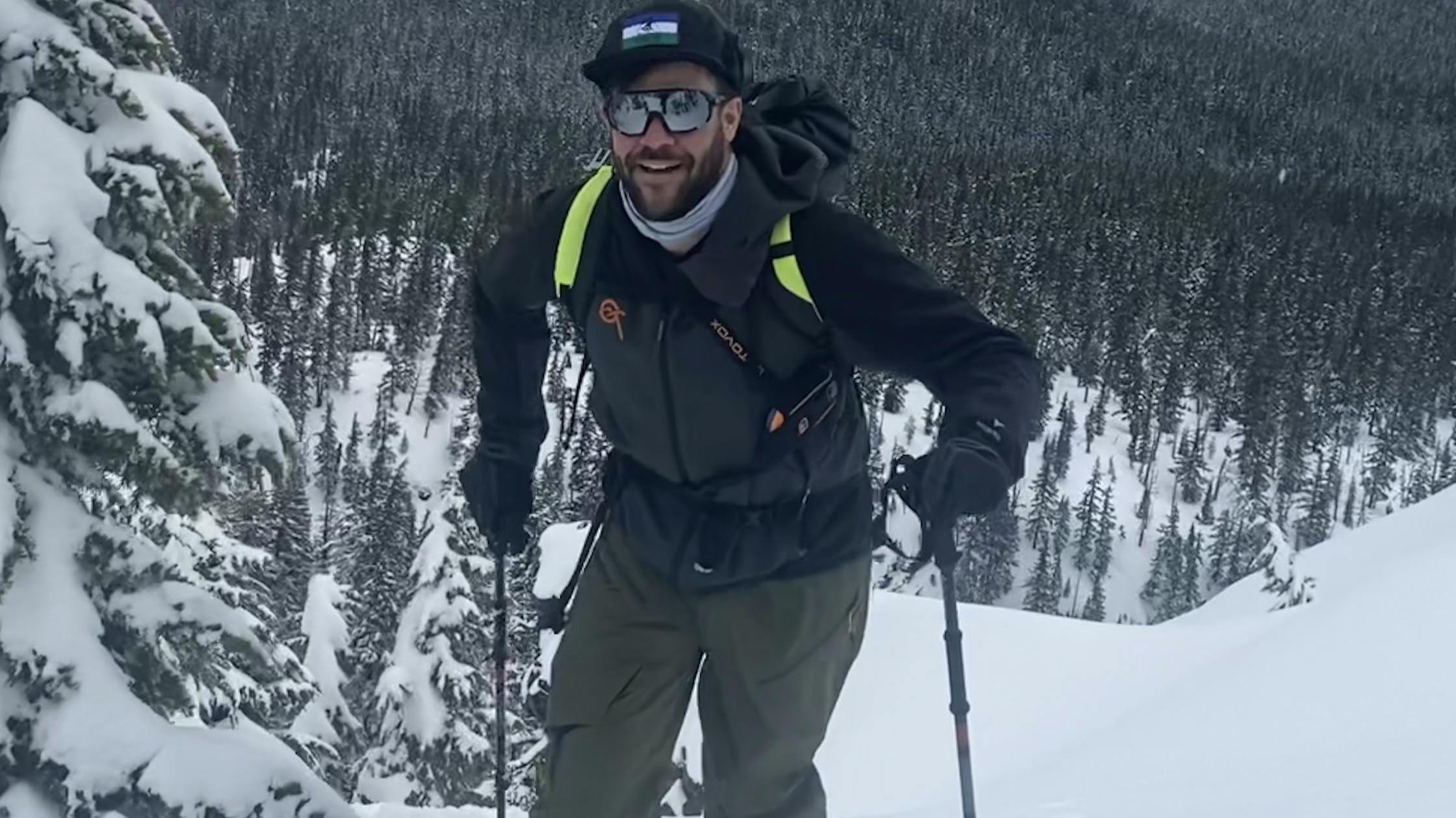 A man walking uphill on skis. 